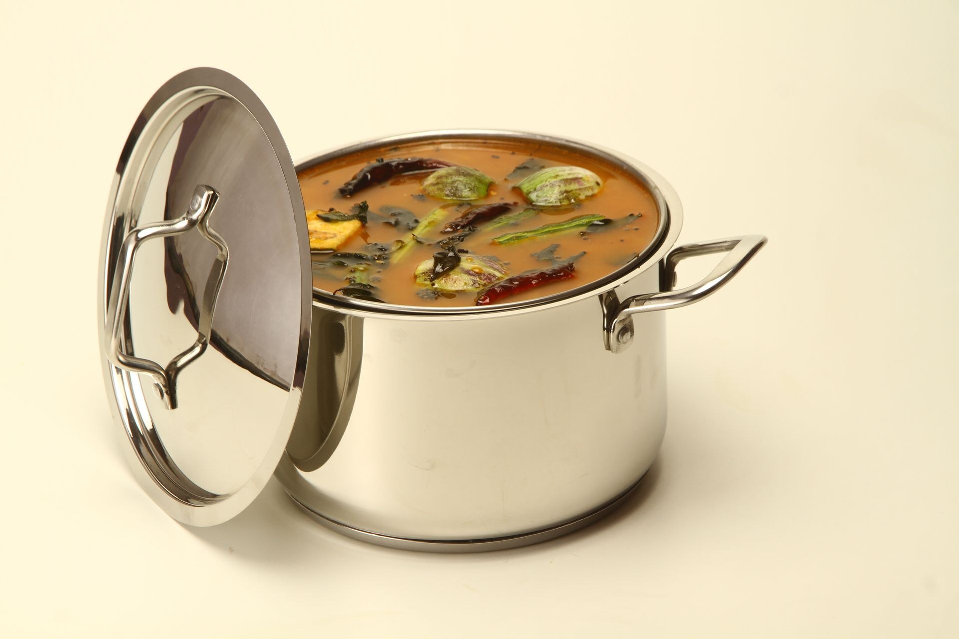 Stainless steel frying pan with stay-cool handle on gas burner